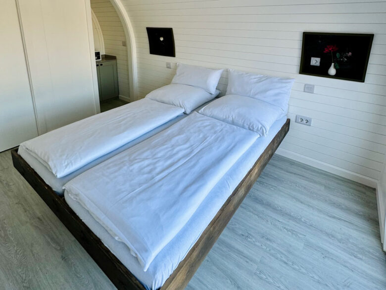 Doppelbett im hellen Schlafbereich der DuoLodge, tiny house in Brandenburg mit Hotelkomfort