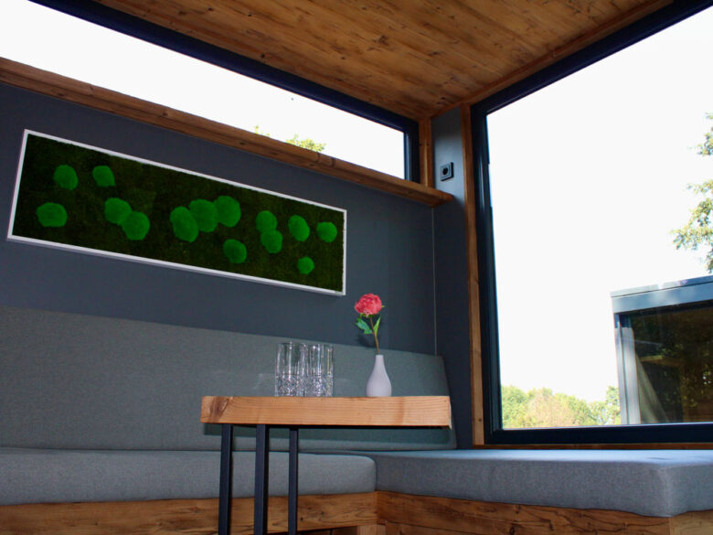 Sitzecke mit Mooswand und Fensterfront im PureCube, übernachten mit Hotelkomfort
