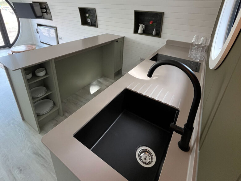 Küchenzeile mit schwarzer Spüle in der DuoLodge, glamping in Brandenburg modern ausgestattet