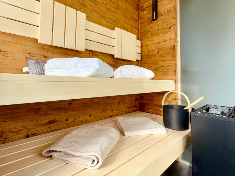 Eigene Sauna im SpaCube mit Holzbänken, Aufgusskübel und frischen Handtüchern