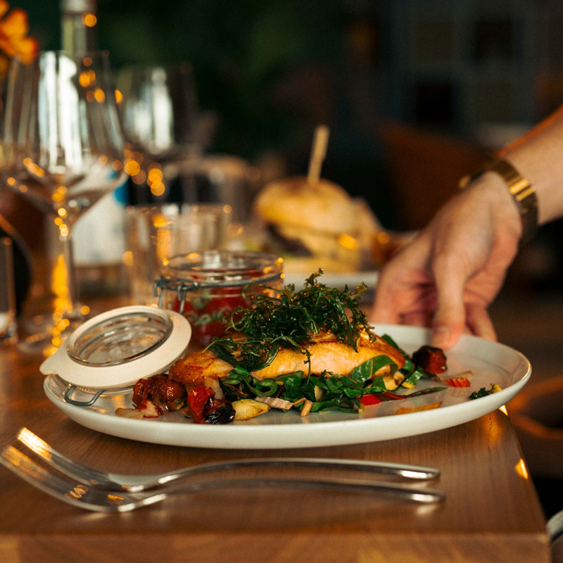 Frisch angerichtetes Lachsfilet mit Salat wird im Restaurant der CARAVANSEREI serviert