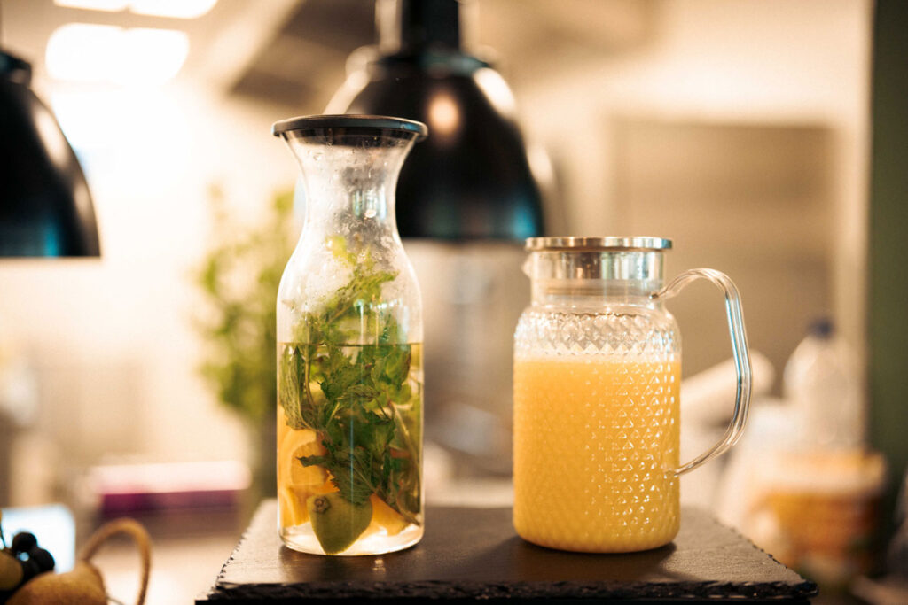 Karaffen mit Infused Water und frischem Saft im Sommergarten des Naturresorts CARAVANSEREI