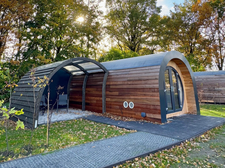 Seitenansicht der NestLodge mit überdachtem Freisitz im Grünen, tiny house mit Whirlpool zubuchbar
