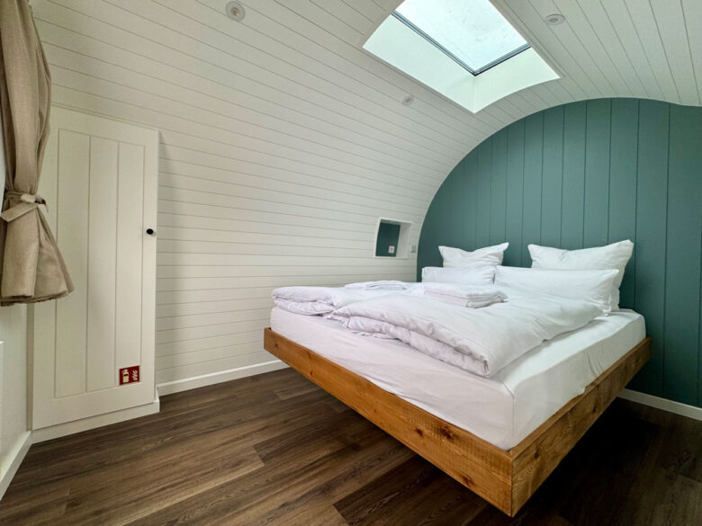 Schlafbereich der PodLodge mit Doppelbett und Dachfenster, tiny house mit Whirlpool zubuchbar